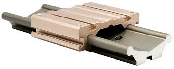 Egy sz�rke sz�n� �nekn� cs�sz� line�ris vezet�k Uniguide D t�pus furatokkal a k�zep�n egy beige sz�n� line�ris kocsi a tetej�n n�gy furattal